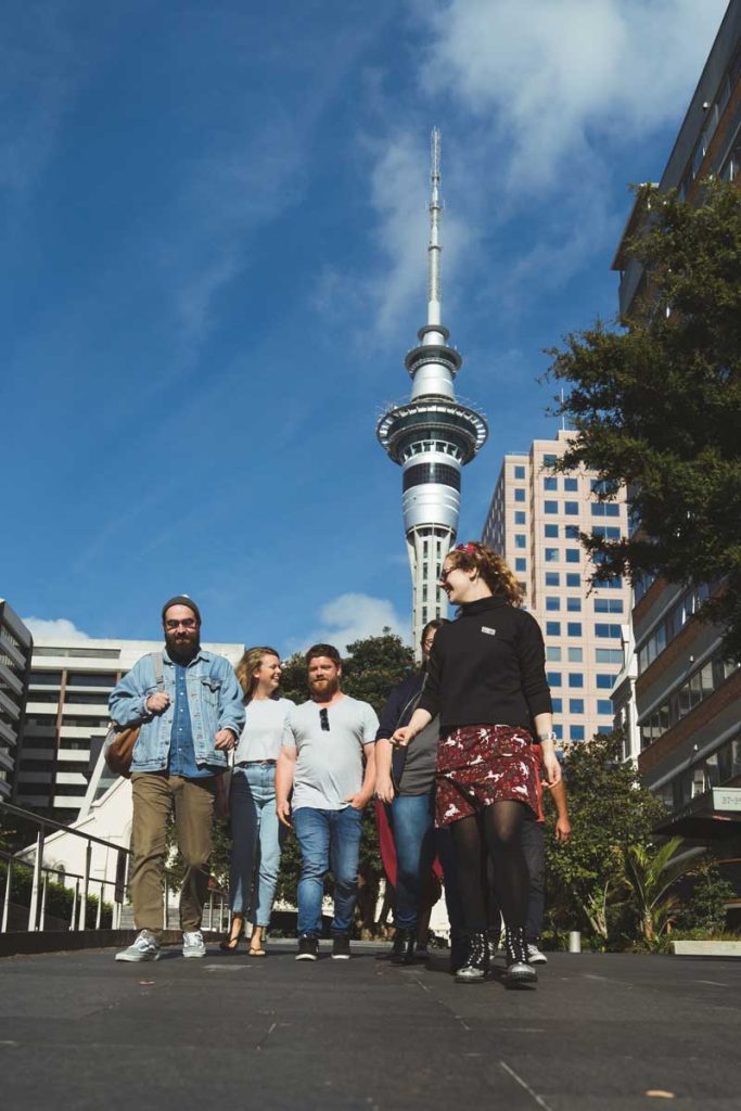 A group walking in front of the Sky Tower